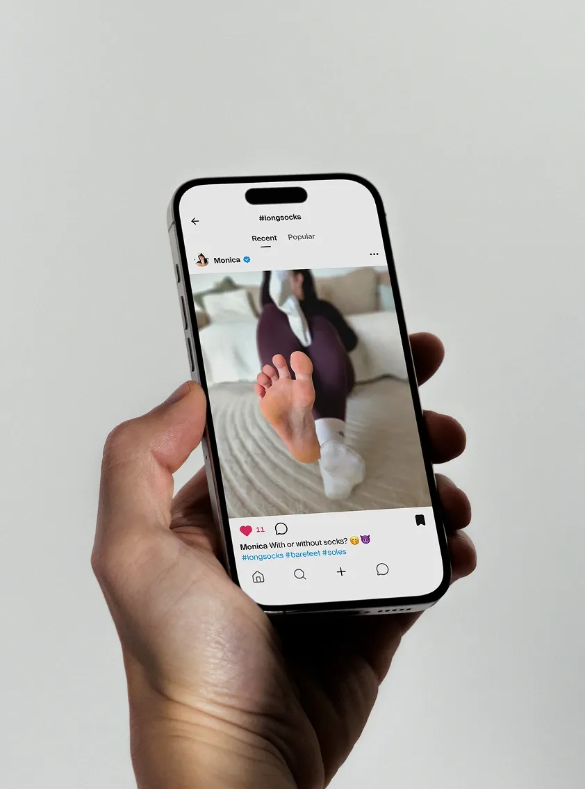 The MyFeetish feed open on a phone held in one hand, showing a post under the
